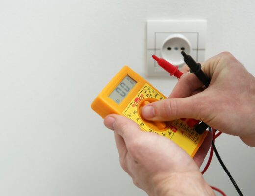 Ilustrační stock: elektrikář ověřuje zkoušečku napětí na živém zdroji před začátkem práce na elektrickém okruhu, civilně, bez loga či značek nářadí